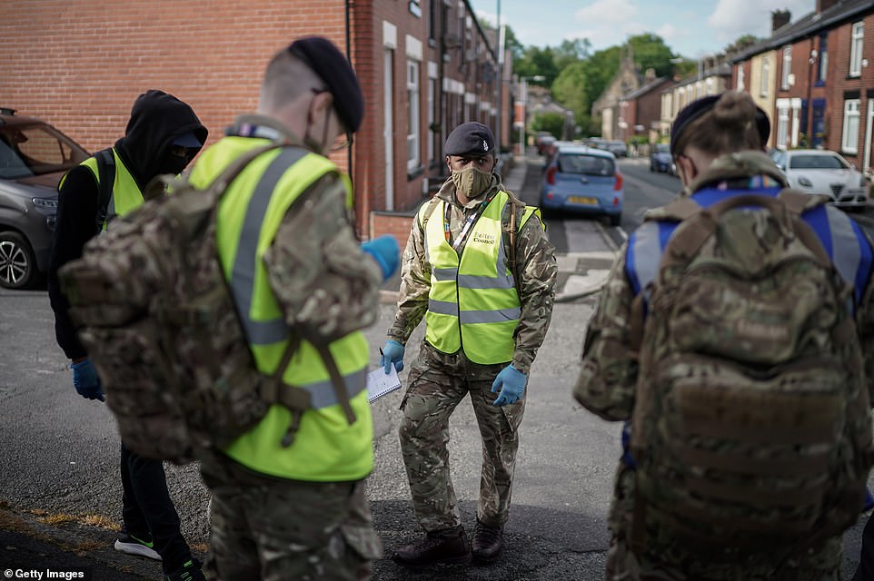 Gunners from the Royal Horse Artillery distribute Covid-19 polymerase chain reaction (PCR) tests to local residents on May 24, 2021 in Bolton