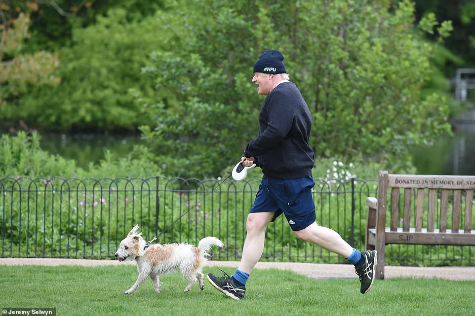 Boris Johnson is pictured jogging in Westminster Park this morning with his dog Dilyn, a Jack Russell cross